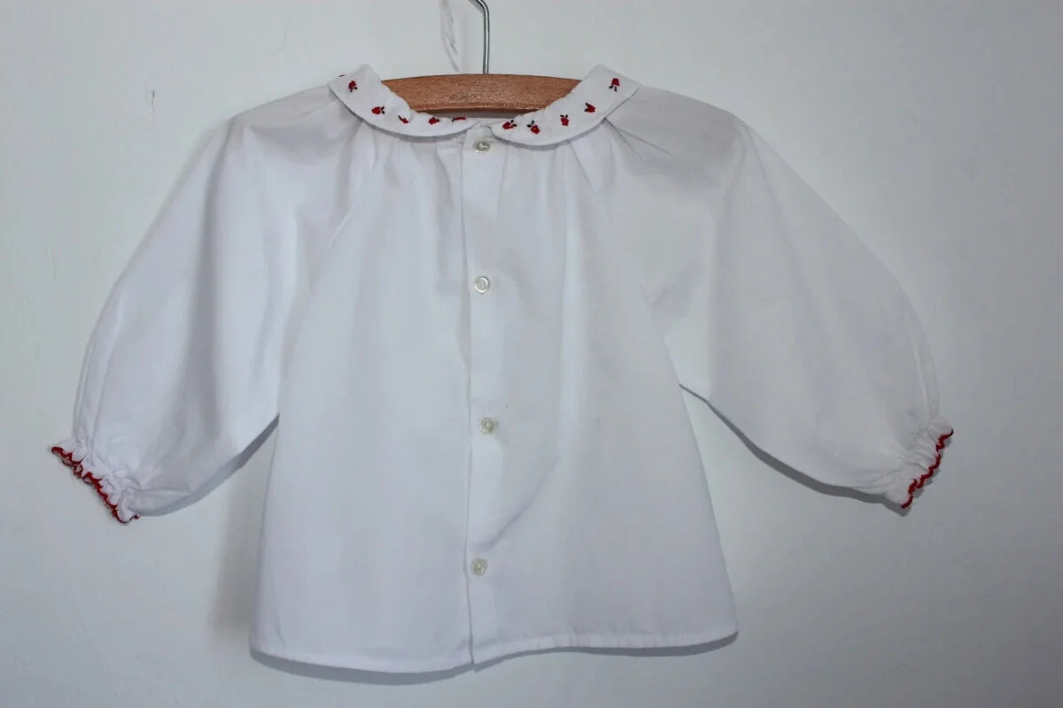 tweedehands witte katoenen jacadi blouse met rode accenten op de volantkraag en lange mouwen in maat 68