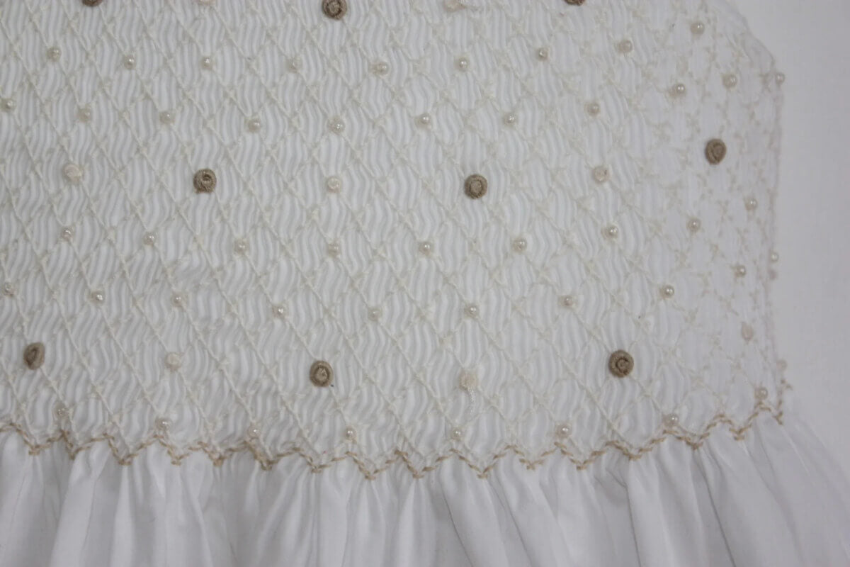 tweedehands mouwloze zomerse katoenen wit met creme en beige gesmockte jurk van jacadi in maat 104